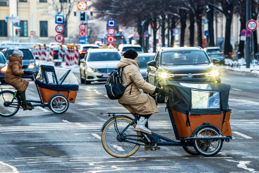 Donne che trasportano biciclette da carico attraversano Prinzregentenstrasse a Monaco.