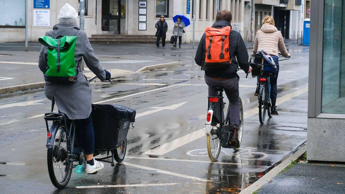 Tre ciclisti sotto la pioggia a Dusseldorf