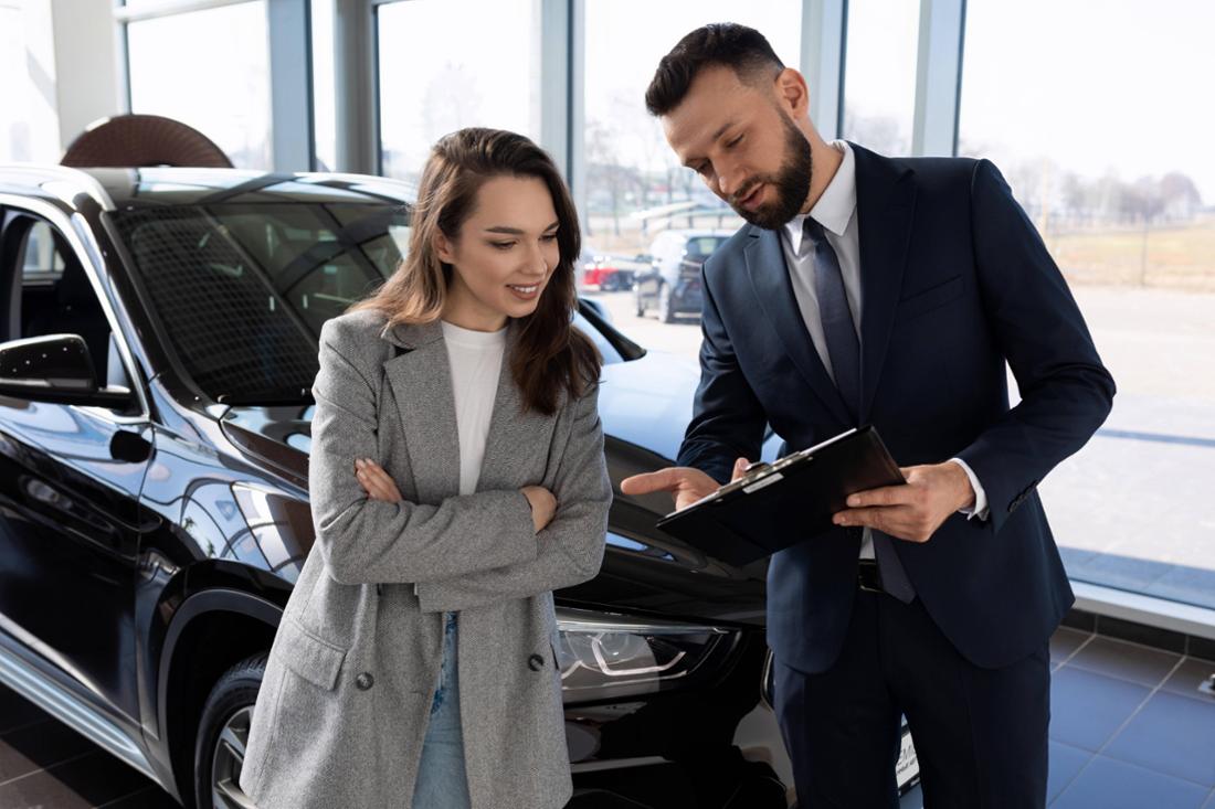 Un concessionario di automobili consiglia al suo cliente di acquistare un'auto.