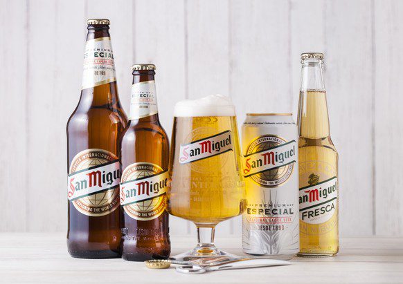 Londra, Regno Unito - 27 aprile 2018: Bottiglie di vetro di birra San Miguel Lager su fondo di legno con vetro originale. Il marchio di birra San Miguel è il marchio di punta di San Miguel Brewery Inc, la più grande...